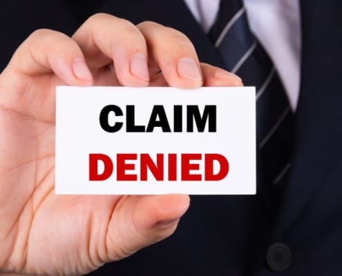 Man holding claim denied sign